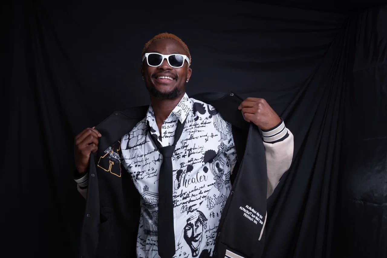 Lachender Mann mit Sonnenbrille öffnet seine Jacke im Studio